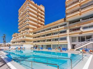 a large building with a swimming pool in front of it at Playa Honda Apartamento Abeja in Playa de las Americas