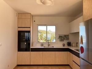 eine Küche mit einem Waschbecken und einem Fenster in der Unterkunft Villa La Ronde des Soleils in Coti-Chiavari