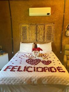 a bed with a teddy bear on top of it at Chalé Céu estrelado in Caruaru