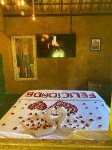 uma cama com dois cisnes feitos de rosas em Chalé Céu estrelado em Caruaru