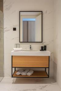 a bathroom with a sink and a mirror at Hotel & Spa Ponta Plaza in Budva