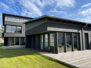a modern house with glass doors and a lawn at Ferienwohnung Cleo in Mirow