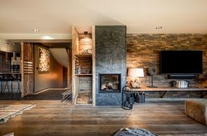 a living room with a fireplace and a flat screen tv at Chalet Virolo in Megève