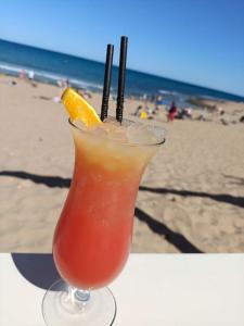 a drink sitting on a table at the beach at Sandy Home - Élvezd a tengerpartot! in La Mata