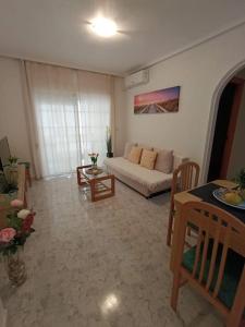 a living room with a white couch and a table at Sandy Home - Élvezd a tengerpartot! in La Mata