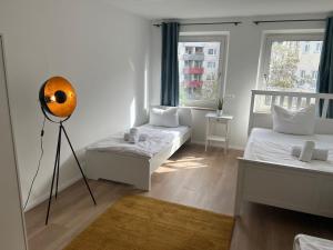 um quarto branco com 2 camas e uma ventoinha em Zentrale Apartments in Bayreuth em Bayreuth