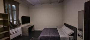 Dormitorio pequeño con cama y TV en Stanza privata in dimora storica, 