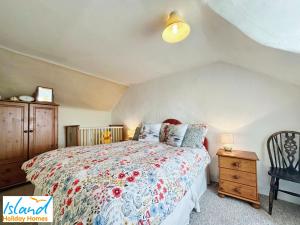 St Catherines View في فنتنور: غرفة نوم مع سرير مع لحاف متهالك