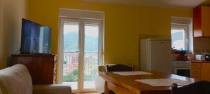 eine Küche mit gelben Wänden und einem Tisch mit einem TV in der Unterkunft 2-level apartment with terraces by the sea in Budva