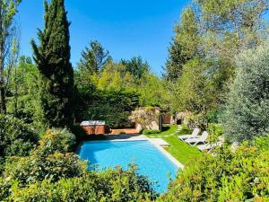 una piscina en un jardín con árboles en Le Clos Pastel en Virac