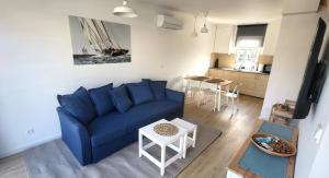 a living room with a blue couch and a table at Na Pokładzie in Dębki