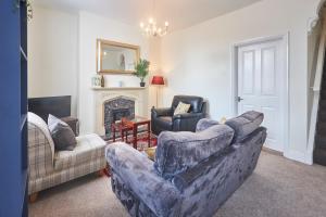 a living room with two couches and a fireplace at Cosy and convenient cottage in Bishop Auckland