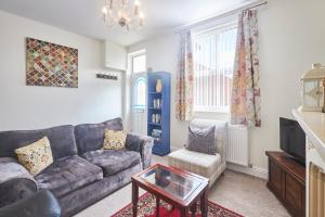 a living room with a couch and a table at Cosy and convenient cottage in Bishop Auckland
