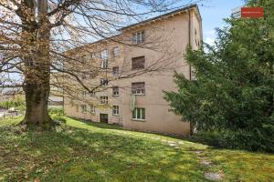 a large building with a tree in front of it at 15-Min to Zurich Center: Cozy Apartment in Zürich