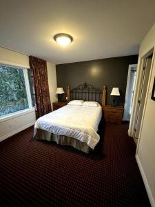 ein Schlafzimmer mit einem großen Bett und einem Fenster in der Unterkunft Peaceful Golf Spa in Collingwood