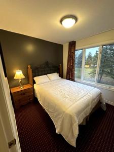 ein Schlafzimmer mit einem großen Bett und einem Fenster in der Unterkunft Peaceful Golf Spa in Collingwood