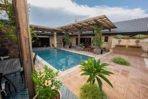 a swimming pool in a backyard with a pergola at Bella Bohemia Spa, Venue and Guest Farm in Roodeplaat