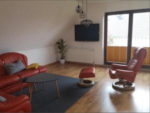 a living room with a couch and chairs and a tv at Ferienwohnung Familie Ossenbühl in Todendorf