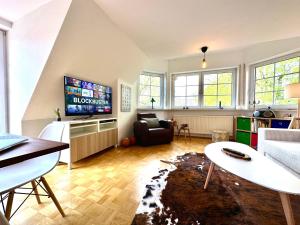 a living room with a couch and a tv at Heideidyll - Geräumige Wohnung mit Balkon & Garage in Schneverdingen