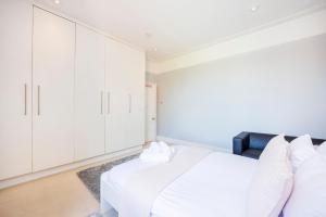 a bedroom with a white bed and white cabinets at 6 Bedroom House by AV Stays Acton Sleeps 11 Free Parking in London