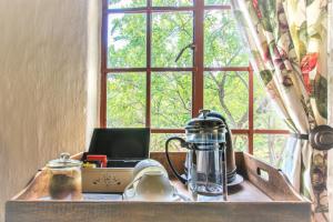 a window with a table with a tea kettle and a laptop at Shikwari Suites - Shikwari Nature Reserve in Hoedspruit