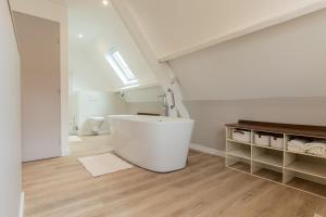 een witte badkamer met een bad en een wastafel bij Villa Opale in Audinghen