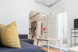 een woonkamer met een blauwe bank en een tafel bij Sagrada Familia ART Apt By MyRentalHost in Barcelona