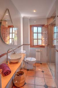 a bathroom with a toilet and a sink and a mirror at Casa La Serena in Lusa