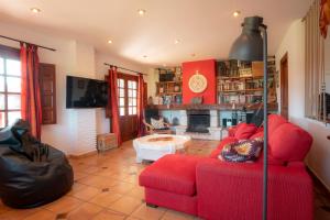 a living room with a red couch and a fireplace at Casa La Serena in Lusa
