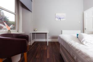 een slaapkamer met een bed, een bureau en een raam bij Warm&Welcoming City Centre Apartments by Meadows 8 in Edinburgh