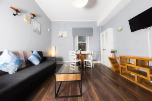 een woonkamer met een zwarte bank en een tafel bij Warm&Welcoming City Centre Apartments by Meadows 8 in Edinburgh