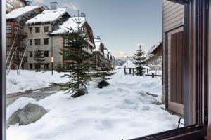 una calle cubierta de nieve con árboles y edificios en Luderna - Apartamento Val de Ruda A17 era Cabana, en Baqueira Beret