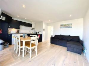a living room with a couch and a table and chairs at 107 Brambles Chine, Holiday Coastal Chalet in Freshwater +11 photos