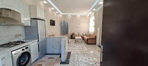 een keuken met een wasmachine en een woonkamer bij Goygol House in Aşıqlı