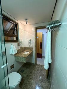 a bathroom with a toilet and a sink and a mirror at Casa Mauá 312 in Rio de Janeiro