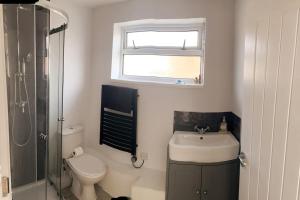 a bathroom with a toilet and a sink and a window at 107 Brambles Chine, Holiday Coastal Chalet in Freshwater