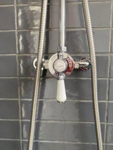 a shower with a thermometer attached to a wall at 107 Brambles Chine, Holiday Coastal Chalet in Freshwater