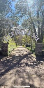 an archway over a dirt road in a park at Rock Park Penthouse in Llandrindod Wells