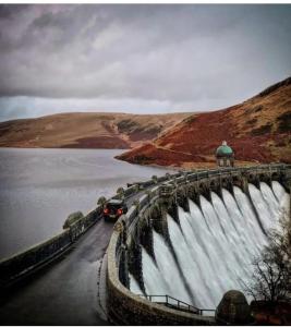 a car driving on a bridge over a dam at Rock Park Penthouse in Llandrindod Wells