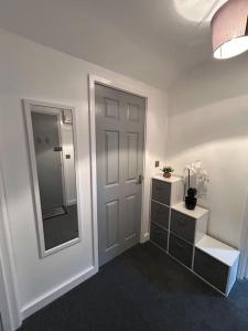 a white room with a door and a mirror at Rock Park Penthouse in Llandrindod Wells