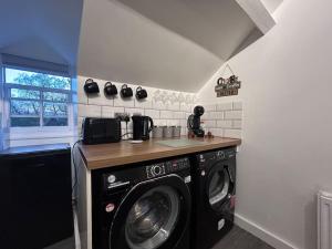 a laundry room with a washing machine and a counter at Rock Park Penthouse in Llandrindod Wells +6 photos