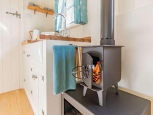 um forno a lenha numa cozinha com um lavatório em 1 Bed in Hayfield 87592 em Mellor