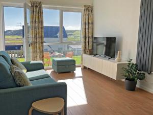 a living room with a blue couch and a flat screen tv at 1 Bed in Tenby 89847 in Penally