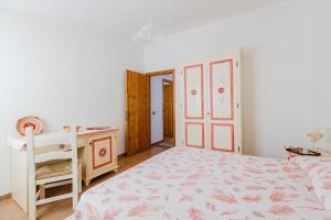 a bedroom with a bed and a desk and a table at Domu de Maria in Torre Dei Corsari