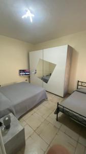 1 dormitorio con 2 camas y pared de cristal en Camera doppia o tripla con bagno "Nel Cuore di Faenza" en Faenza