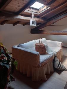 a room with a bed with a basket on it at La soffitta di Megan in Cesano