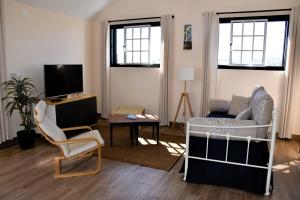 a living room with a couch a chair and a tv at Serenity Views, Silver Coast, PT in Bombarral