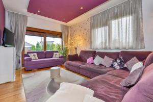 uma sala de estar com mobiliário roxo e um tecto roxo em 4 bedrooms villa with private pool jacuzzi and enclosed garden at Turcin em Črnec Biškupečki
