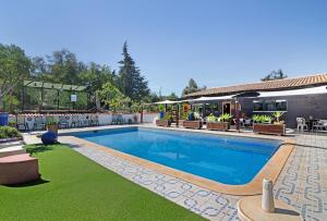 uma piscina num resort com cadeiras e mesas em Quinta Alegre em Porches