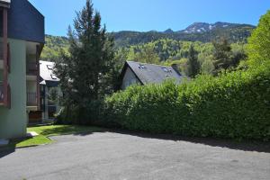 a hedge in front of a house and a building at Studio st-lary in Saint-Lary-Soulan